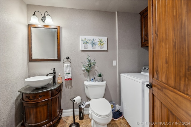 bathroom with toilet, washer / clothes dryer, vanity, and tile patterned floors