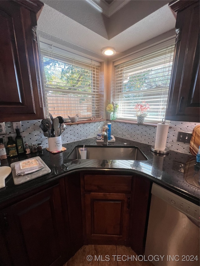 kitchen with sink, dishwasher, dark brown cabinets, and dark stone counters