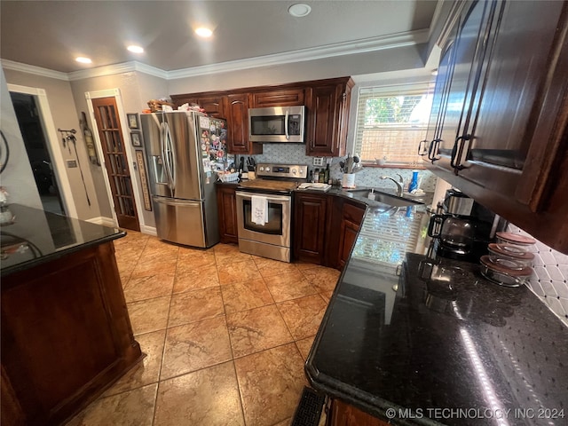 kitchen featuring tasteful backsplash, dark stone countertops, ornamental molding, sink, and stainless steel appliances