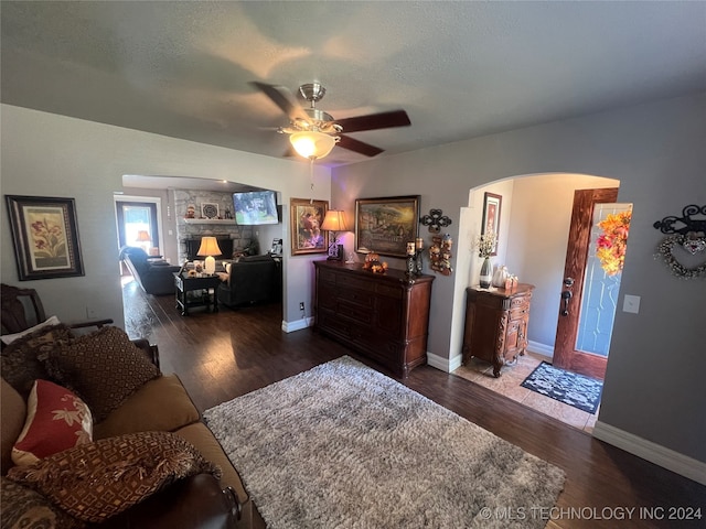 living room with dark wood-type flooring and ceiling fan