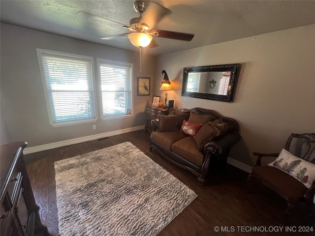 living room featuring dark hardwood / wood-style flooring, a textured ceiling, and ceiling fan