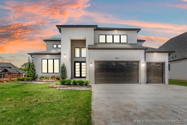 modern home featuring a front lawn, driveway, and stucco siding