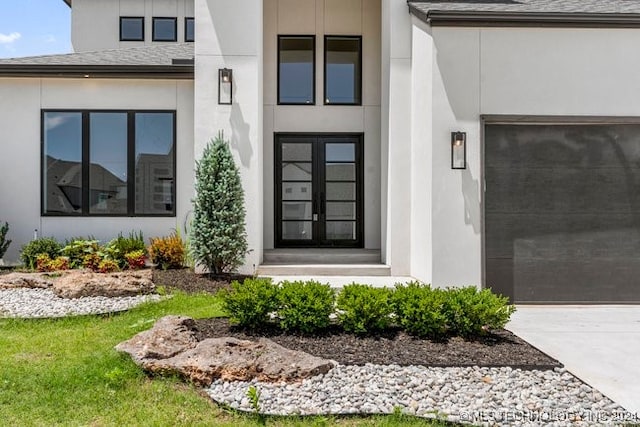 entrance to property featuring a shingled roof and stucco siding