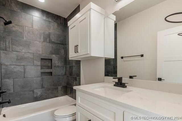 full bathroom featuring vanity, toilet, and tiled shower / bath