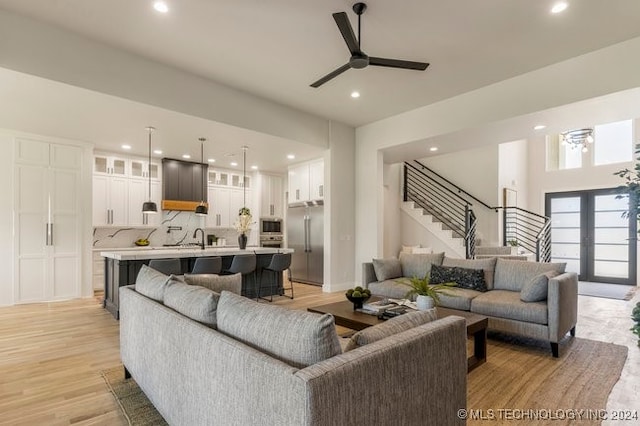 living room with sink, ceiling fan, french doors, and light hardwood / wood-style flooring