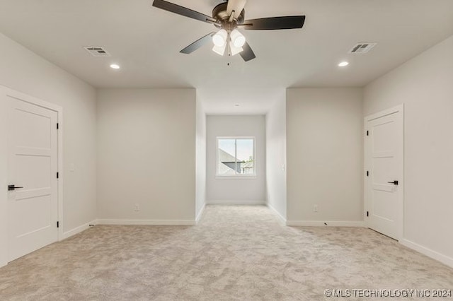 spare room with light colored carpet and ceiling fan