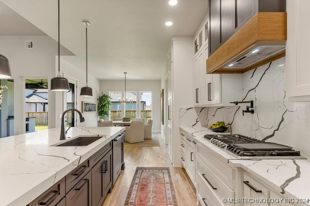 kitchen featuring white cabinetry, sink, decorative light fixtures, and stainless steel appliances