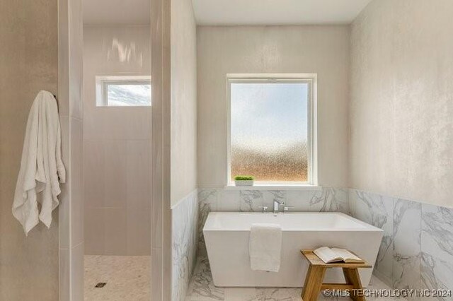 bathroom with tile walls, plus walk in shower, and breakfast area