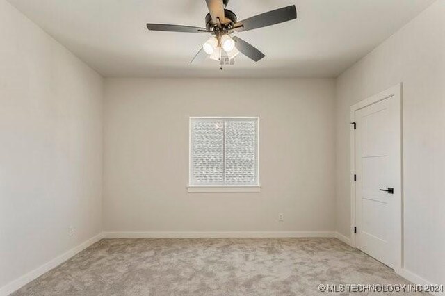 carpeted empty room featuring ceiling fan