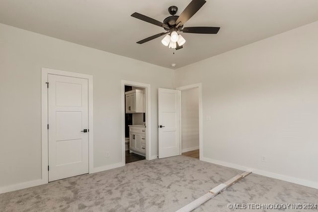 unfurnished bedroom with ceiling fan, carpet flooring, and ensuite bathroom