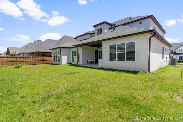 back of house with a patio area and a yard