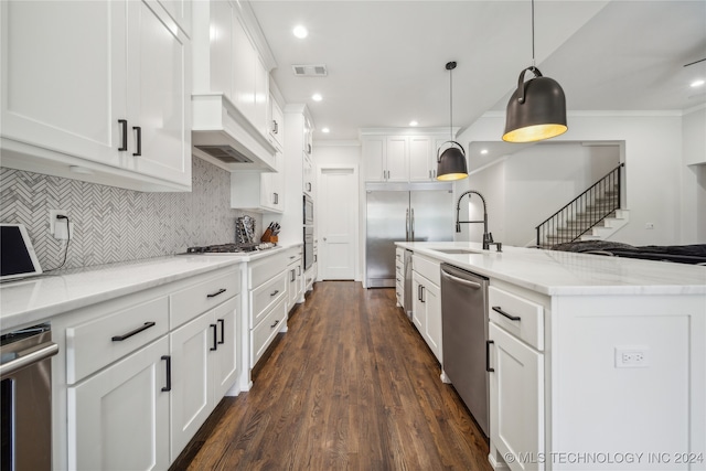 kitchen with light stone countertops, dark hardwood / wood-style flooring, hanging light fixtures, white cabinetry, and stainless steel appliances