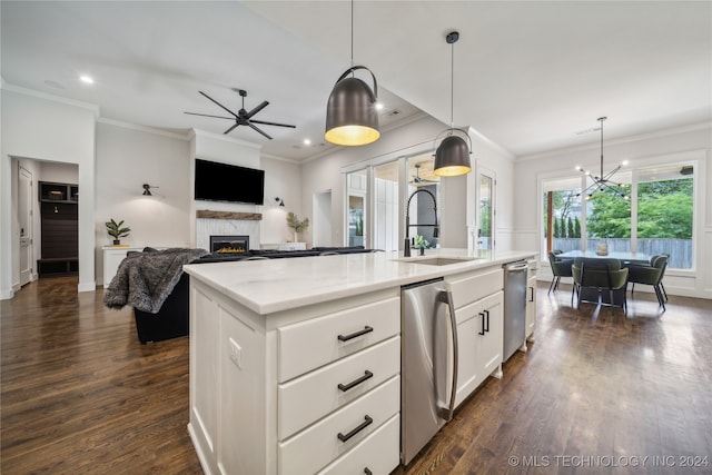 kitchen with dark wood-type flooring, sink, an island with sink, and a high end fireplace