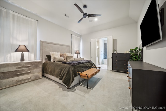 carpeted bedroom with ensuite bath, lofted ceiling, and ceiling fan