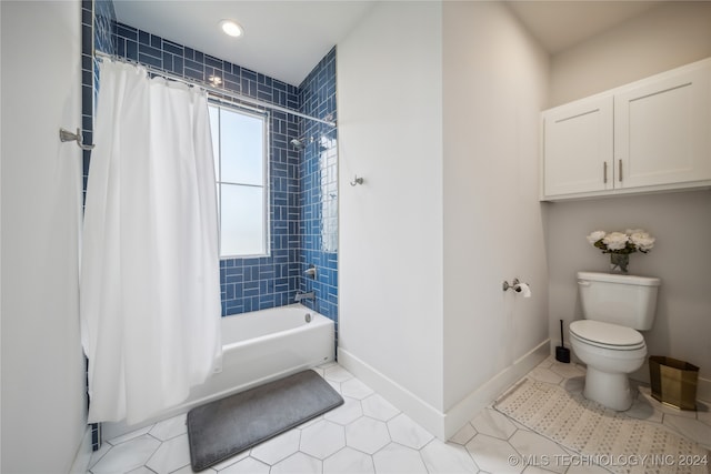 bathroom with tile patterned floors, shower / bath combination with curtain, and toilet