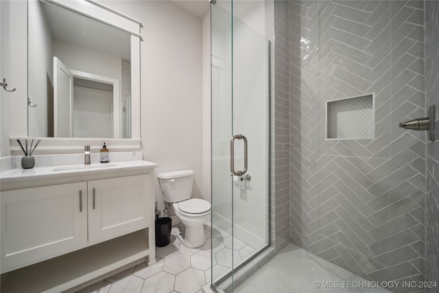 bathroom with vanity, an enclosed shower, toilet, and tile patterned flooring