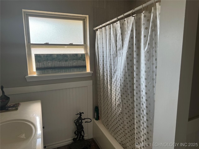 bathroom featuring vanity and shower / bathtub combination with curtain