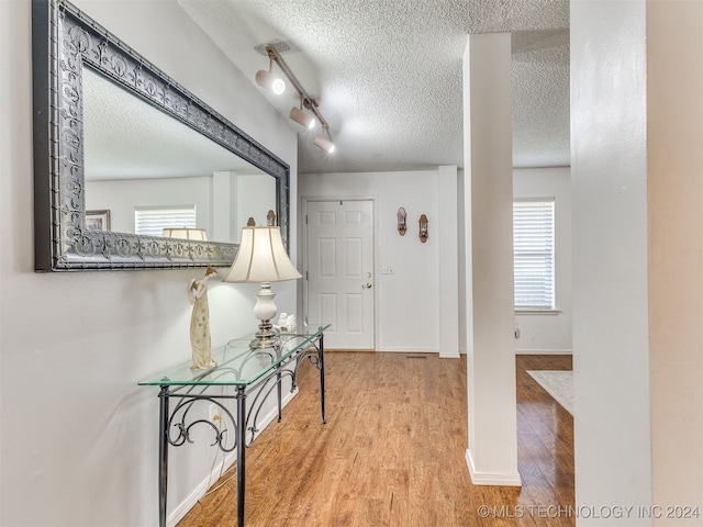 entryway featuring a textured ceiling, hardwood / wood-style flooring, and track lighting