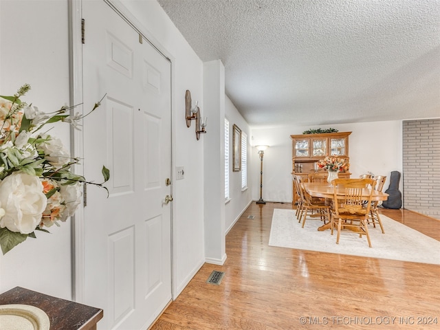 foyer entrance featuring light hardwood / wood-style flooring and a textured ceiling