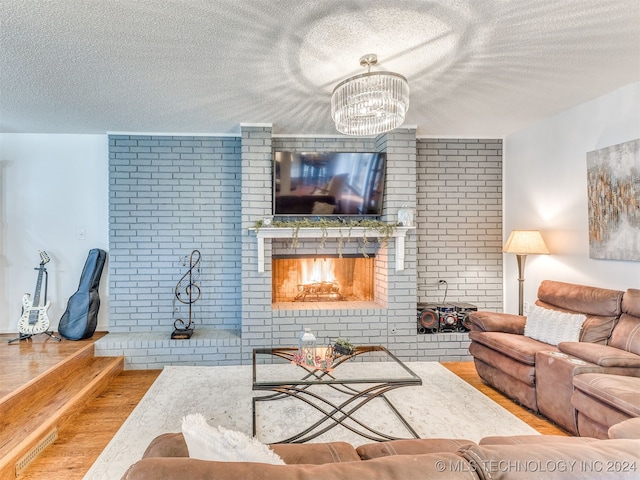 living room featuring wood-type flooring, a textured ceiling, and an inviting chandelier