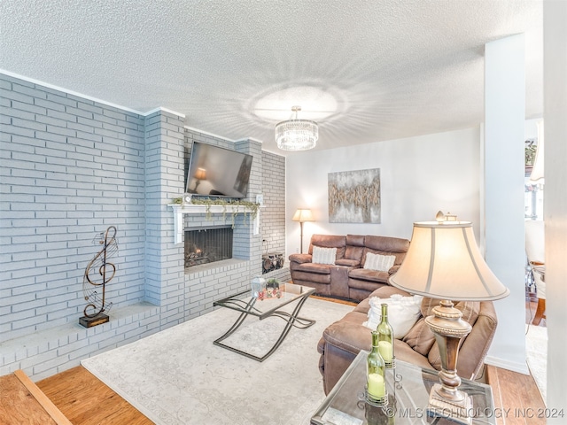 living room featuring hardwood / wood-style floors, brick wall, and a textured ceiling