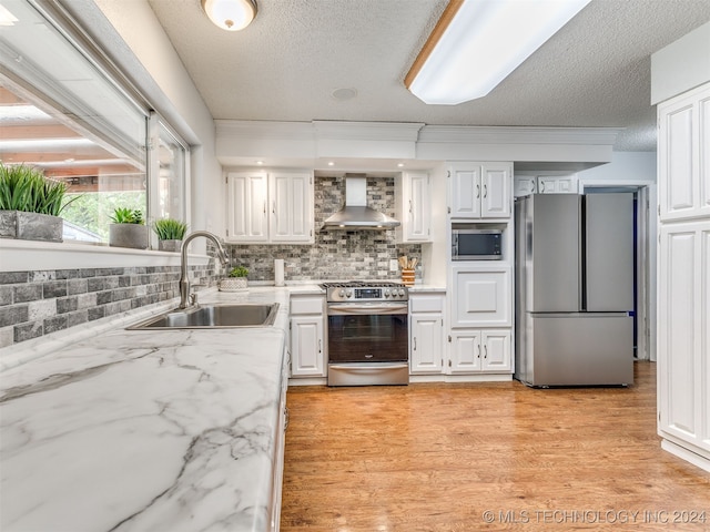 kitchen featuring white cabinets, sink, wall chimney exhaust hood, a textured ceiling, and stainless steel appliances