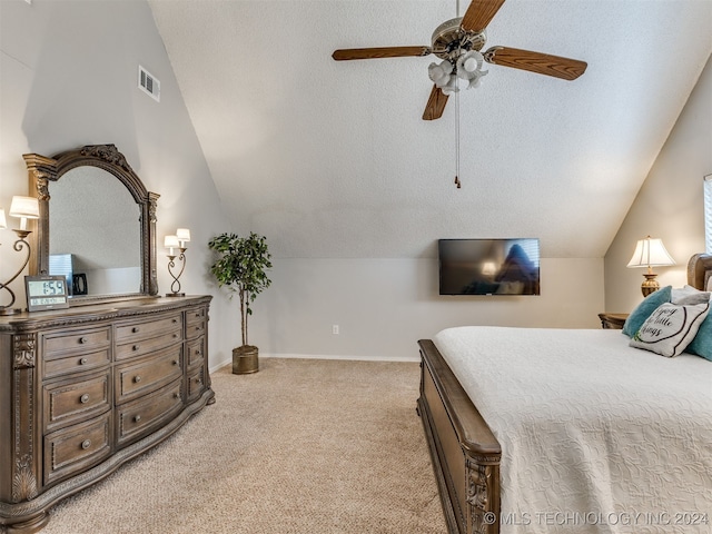 carpeted bedroom with a textured ceiling, vaulted ceiling, and ceiling fan