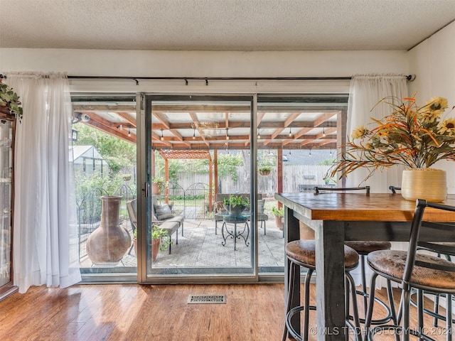 doorway featuring hardwood / wood-style floors and a textured ceiling