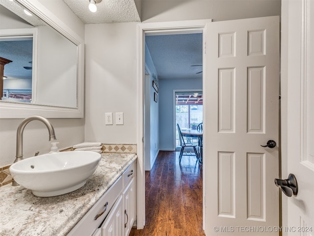 bathroom with vanity, wood-type flooring, and a textured ceiling