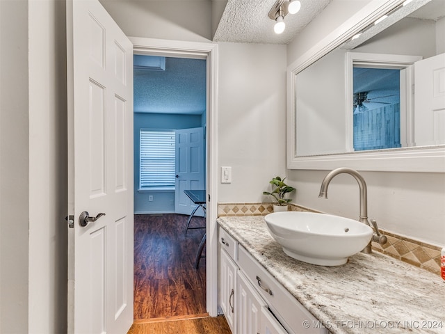 bathroom with vanity, a textured ceiling, and hardwood / wood-style flooring