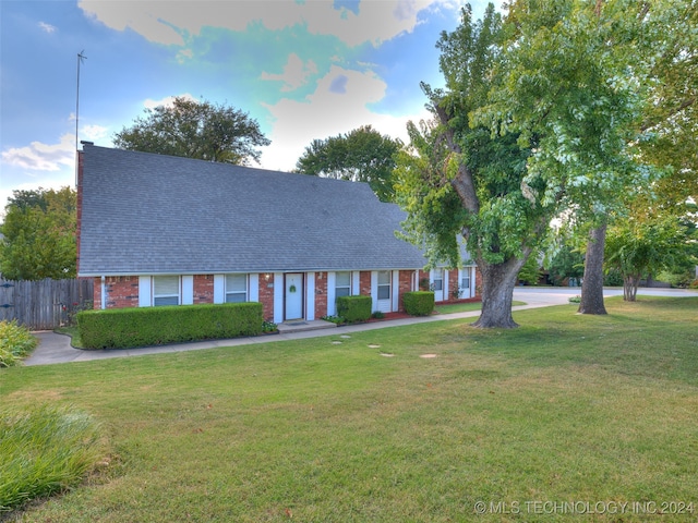 cape cod house featuring a front lawn