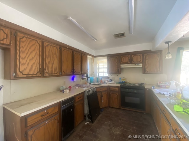 kitchen with sink, black appliances, hanging light fixtures, and dark wood-type flooring