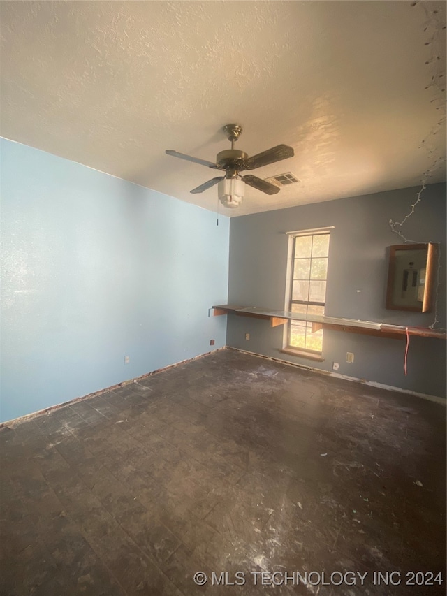 spare room featuring ceiling fan, a textured ceiling, and electric panel