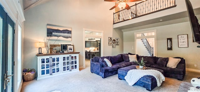 living room with carpet, a towering ceiling, and ceiling fan