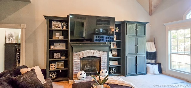 interior space featuring high vaulted ceiling, carpet, and a brick fireplace