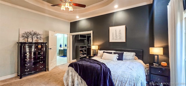 bedroom with a high ceiling, ensuite bathroom, a tray ceiling, ornamental molding, and light carpet