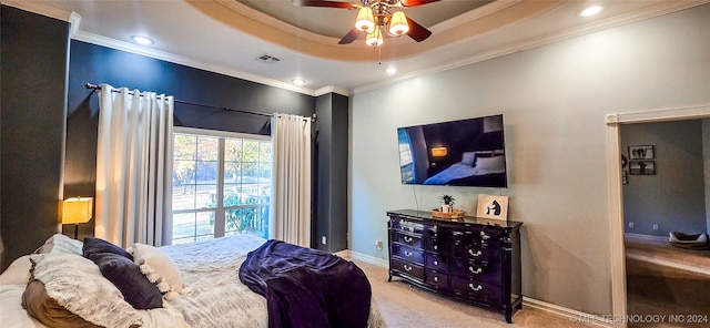 bedroom featuring crown molding, light carpet, a tray ceiling, and ceiling fan