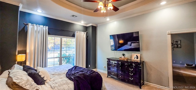 carpeted bedroom with a raised ceiling, crown molding, and ceiling fan