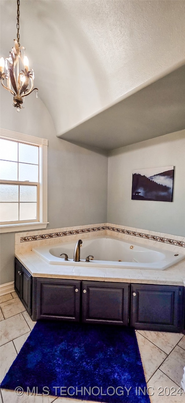 bathroom with tile patterned flooring, a washtub, vaulted ceiling, a notable chandelier, and a textured ceiling