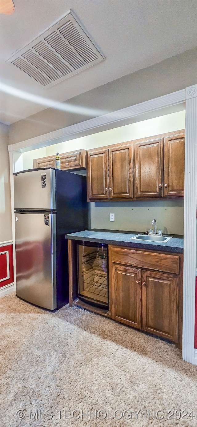 kitchen with stainless steel fridge, sink, and light colored carpet