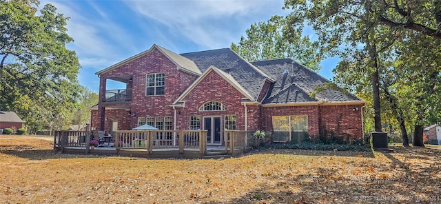 front facade with a wooden deck and a front yard