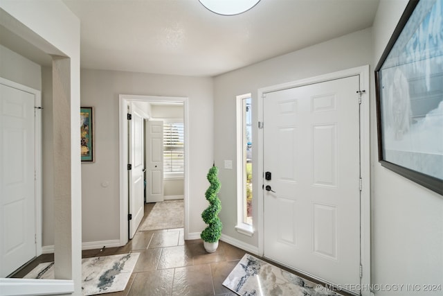 entrance foyer featuring dark tile patterned flooring