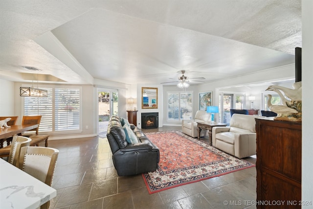 living room with ceiling fan and a textured ceiling