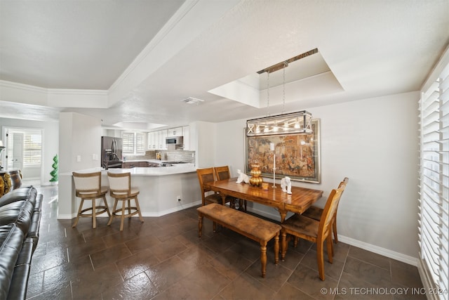 dining area featuring crown molding and a raised ceiling