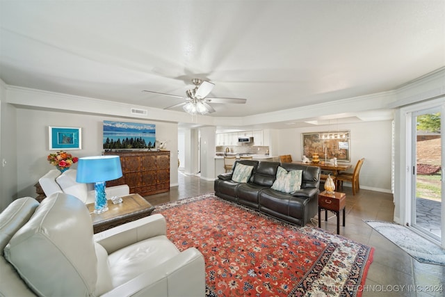 living room featuring ceiling fan, ornamental molding, and tile patterned flooring