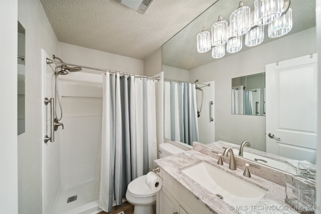 bathroom with toilet, a textured ceiling, curtained shower, and vanity