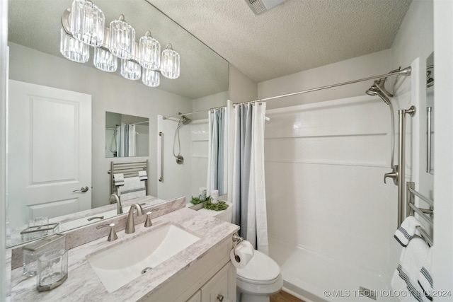 bathroom featuring toilet, a textured ceiling, curtained shower, and vanity