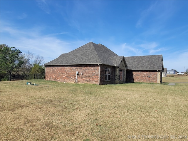 view of side of home with a yard