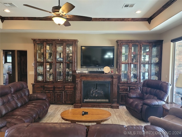 living room featuring crown molding, light hardwood / wood-style flooring, and ceiling fan