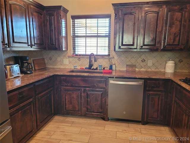 kitchen featuring sink, light wood-type flooring, backsplash, dark brown cabinets, and stainless steel dishwasher